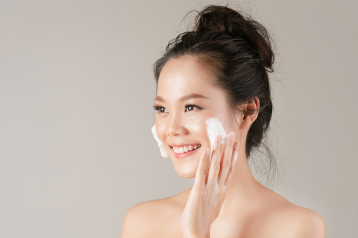 Las mujeres asiáticas van a usar una espuma facial para lavar los cosméticos de la cara photo