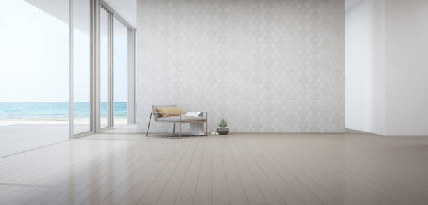 salón con vistas al mar de lujo casa de playa con sillón cerca de puerta en piso de madera. fondo blanco de la pared del patrón del triángulo vacío en casa de vacaciones o chalet de vacaciones. - apartment architecture contemporary beach fotografías e imágenes de stock