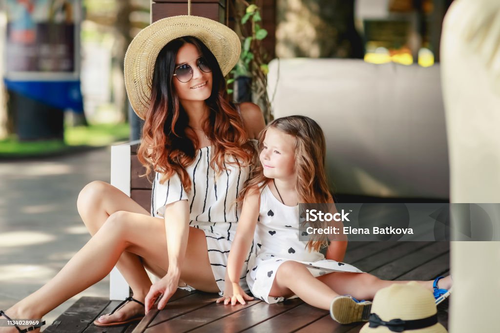 Mother and daughter in a hat during the summer walks. Mother and daughter in a hat during the summer walks Mother Stock Photo