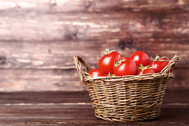 istock Fresh and ripe tomatoes in basket on wooden table 1134029616
