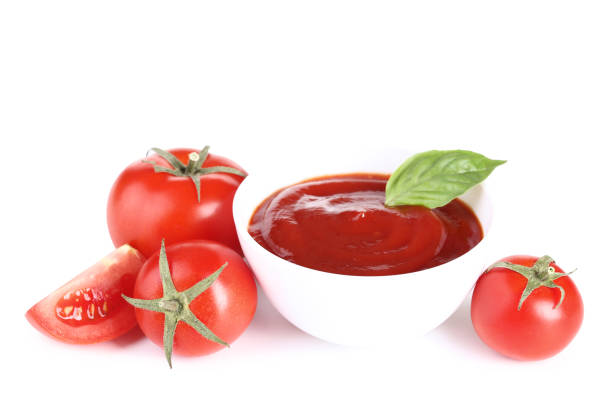 istock Ketchup in bowl with tomatoes and basil leafs isolated on white background 1134029716