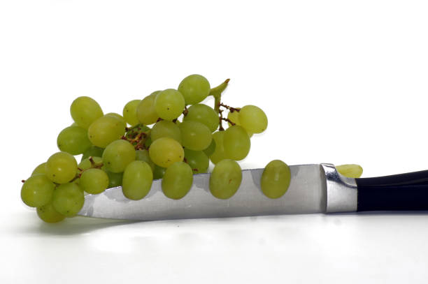 Grapes on the knife released on a white background