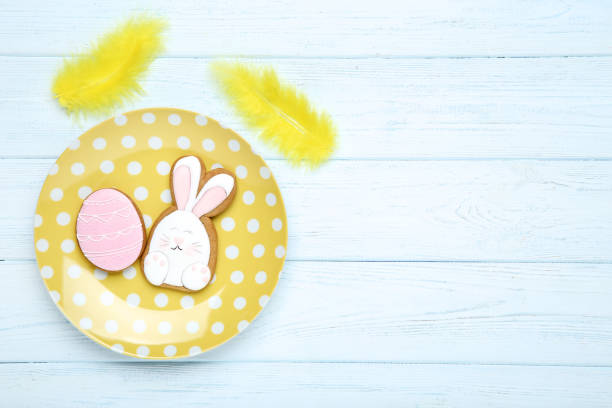 istock Easter gingerbread cookies in plate with yellow feathers on wooden table 1134034927
