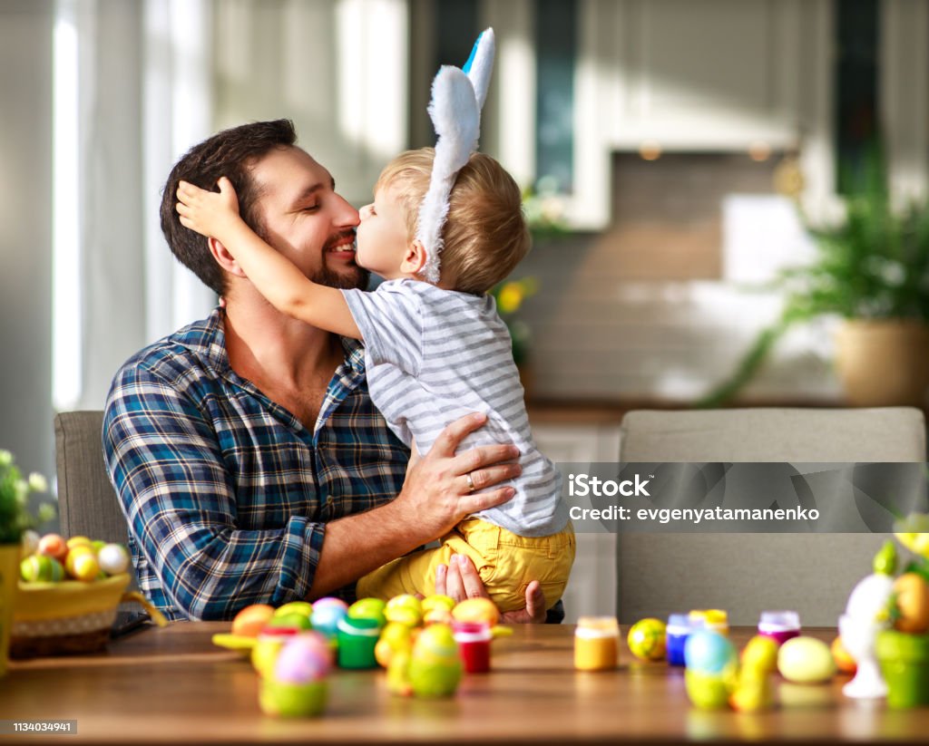 Happy easter! family father and child with ears hare getting ready for holiday Happy easter! family father and child son with ears hare getting ready for holiday Easter Stock Photo