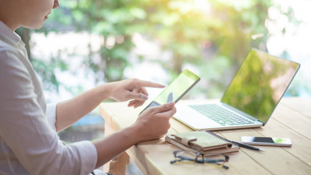istock Young Asian business man using digital tablet working with laptop computer and smartphone in coworking space. Urban lifestyle with modern electronic devices. Internet of things and online app concepts 1134039252