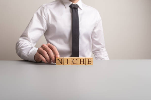 istock Businessman sitting at his office desk assembling a word NICHE 1134039343