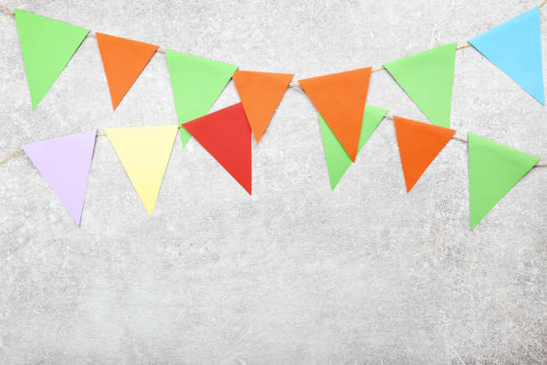 istock Colorful paper flags hanging on gray background 1134039668
