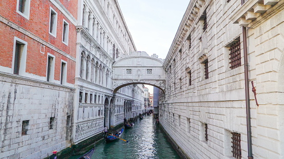 Closer look of the white old buildings in the small lagoon with some gondolas cruising on it in Venice Italy