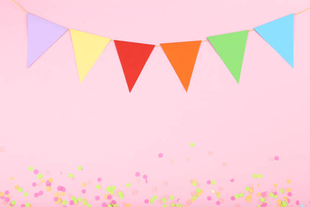 istock Colorful confetti and paper flags on pink background 1134039879