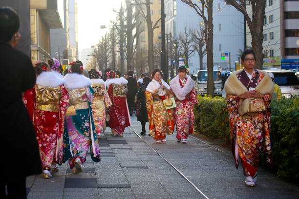 japoneses nuevos adultos vistiendo kimonos en ' día de la llegada de la edad ' en la calle en yokohama - obi sash fotografías e imágenes de stock