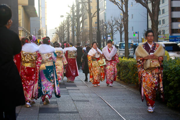 nuovi adulti giapponesi che indossano kimono in "coming of age day" per strada a yokohama - obi sash foto e immagini stock