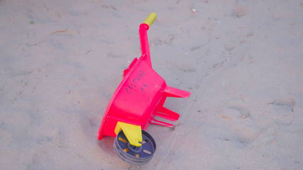 olhar mais próximo do brinquedo do vermelho do carrinho na areia - out of season - fotografias e filmes do acervo