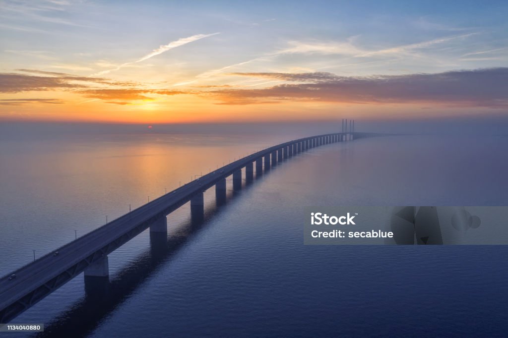 Sunset over the Oresundsbron Oresund Bridge Stunning sunset over the Oresundsbron Oresund bridge between Sweden and Denmark, from Malmö shore. High aerial photograph with drone. Bridge - Built Structure Stock Photo