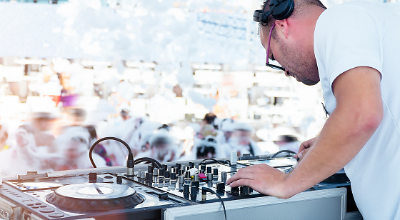 Dj playing at foam party on the beach in music festival