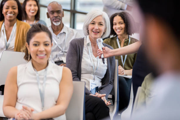 istock Mature woman asks question during business conference 1134043637