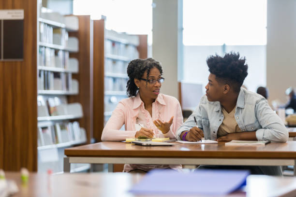 istock Mentor talks to teenage boy in school library 1134045016