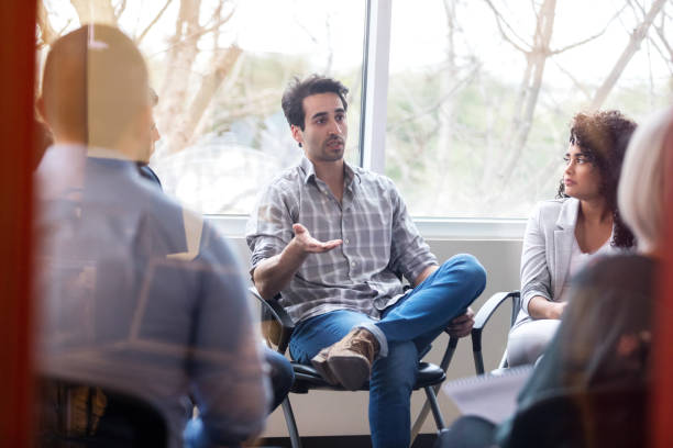 istock Serious mid adult man talks during support group meeting 1134045211