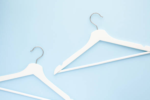 istock White wooden hangers on blue background 1134045233