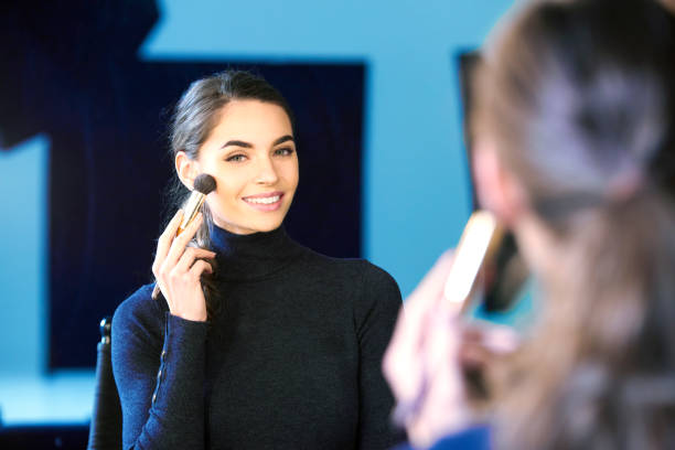 istock Beautiful young woman using brush while applying her makup 1134046324