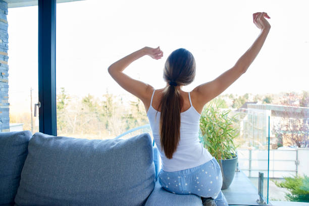 istock Young woman stretching on sofa at home 1134046947
