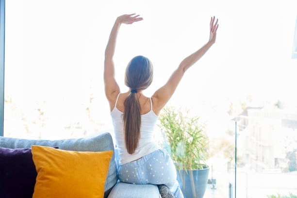 istock Young woman stretching on sofa at home 1134046948