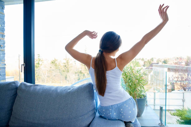 istock Young woman stretching on sofa at home 1134046949