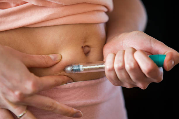 mujer que hace la inyección con la pluma de jeringa - diabetes insulin human fertility injecting fotografías e imágenes de stock