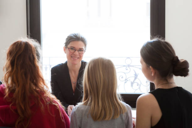 istock three girls in conversation in front of the teacher 1134049663