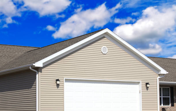 istock Modern tan sided home with garage with blue sky and clouds in the background 1134053164