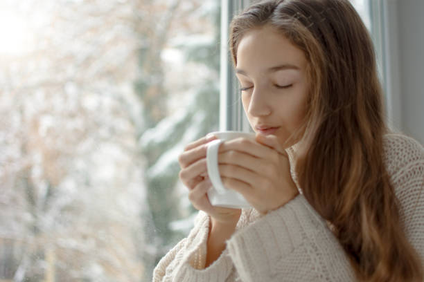 istock Woman drinking coffee in front of window 1134054522