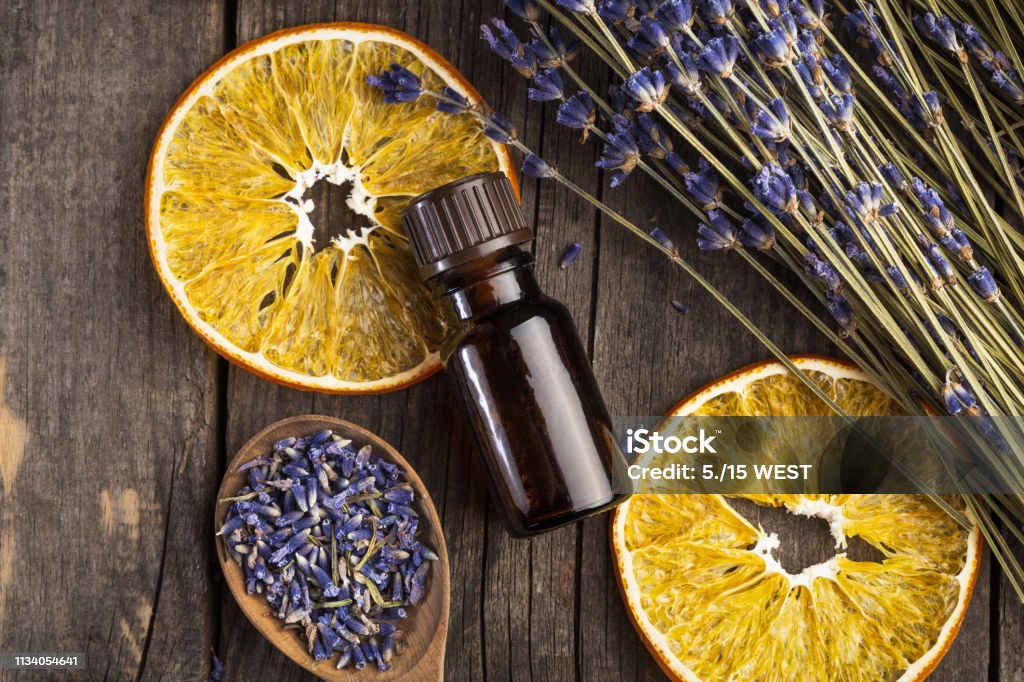 Etherische olie lavendel en oranje droog op een houten tafel, bovenaanzicht - Royalty-free Etherische olie Stockfoto