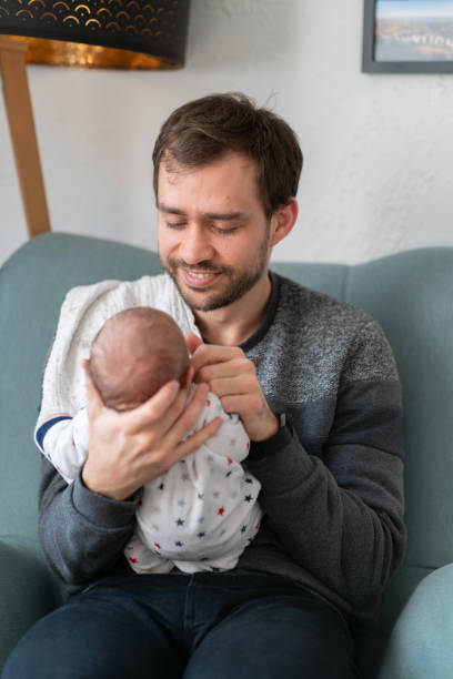 istock Young father happily holding his newborn baby, smiling 1134054708