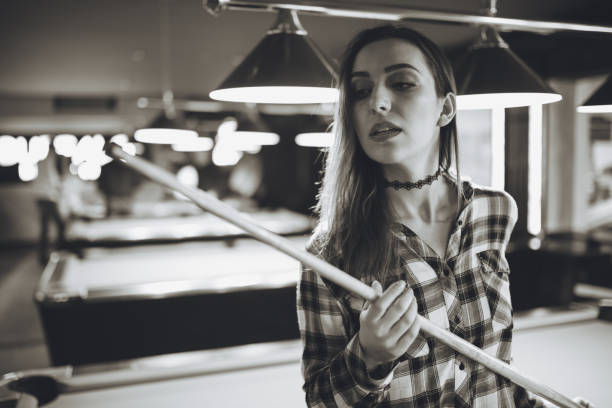 Portrait of a young woman holding pool cue in an entertainment club