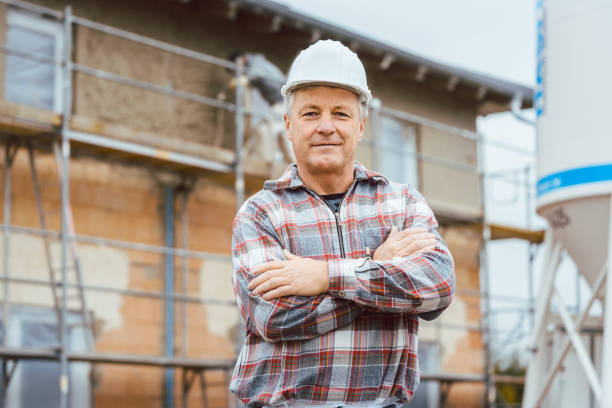 proud plasterer standing in front of scaffold on construction site - protective workwear bricklayer manual worker construction imagens e fotografias de stock