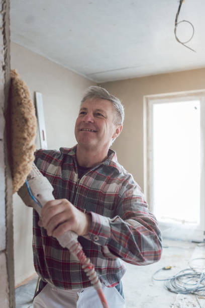 istock Plasterer smoothing interior wall of new homes with machine 1134056856