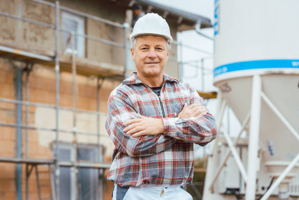 proud plasterer standing in front of scaffold on construction site - protective workwear bricklayer manual worker construction imagens e fotografias de stock