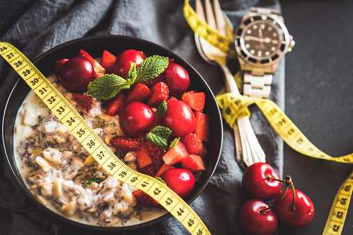 Losing weight with intermittent fasting gets more and more popular, here showed with a clock and a delicious vegan porridge