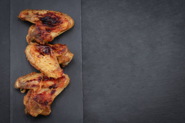 istock Baked chicken wings on dark background with copy space. Top view 1134063536