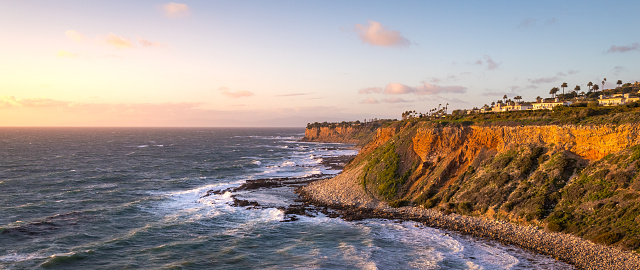 Long exposure shot of waves crashing into the tall cliffs along the Southern California coast at sunset on a windy day, Golden Cove, Rancho Palos Verdes, California