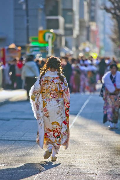 japoneses nuevos adultos vistiendo kimonos y trajes en ' día de la llegada de la edad ' en la calle en yokohama - obi sash fotografías e imágenes de stock