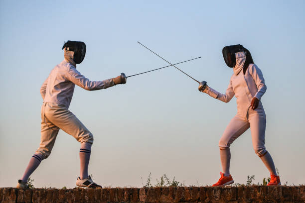 hombre joven y mujer esgrima - fencing sport athlete sword fotografías e imágenes de stock