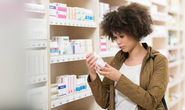 Young Woman Choosing Supplement In Drugstore Young Woman Choosing Supplement In Drugstore probiotic photos stock pictures, royalty-free photos & images