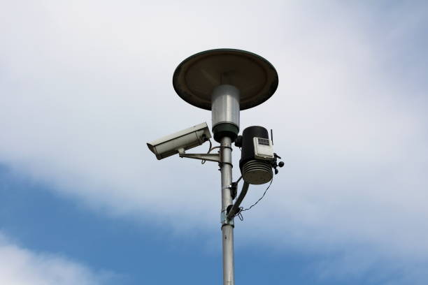 istock Tall street light on metal post with mounted surveillance camera and various measuring devices on cloudy blue sky back 1134069448