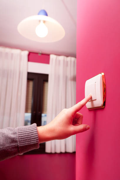 switch on Man's hand pressing light switch meio ambiente stock pictures, royalty-free photos & images