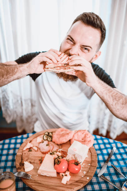 istock Handsome Hungry Male Eating Sandwich 1134069910