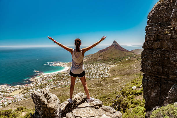 Tourist woman hiking Table Mountain looking at Lion's Head, Cape Town, South Africa Tourist woman hiking Table Mountain looking at Lion's Head, Cape Town, South Africa lions head mountain stock pictures, royalty-free photos & images