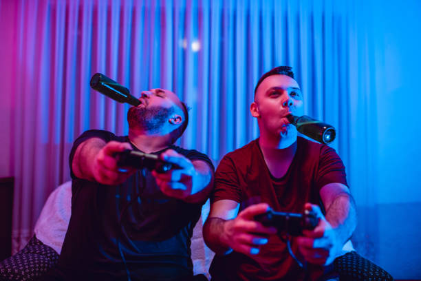 istock Two Male Friends Competing At Video Game And  Drinking Beer 1134069947