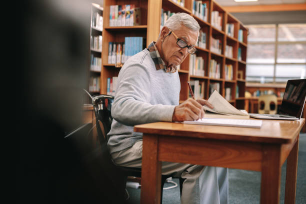 istock Senior man writing sitting in a university classroom 1134070906