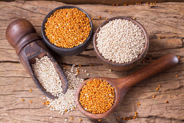 las semillas de quinoa y el mijo rojo - quinoa spoon wood photography fotografías e imágenes de stock