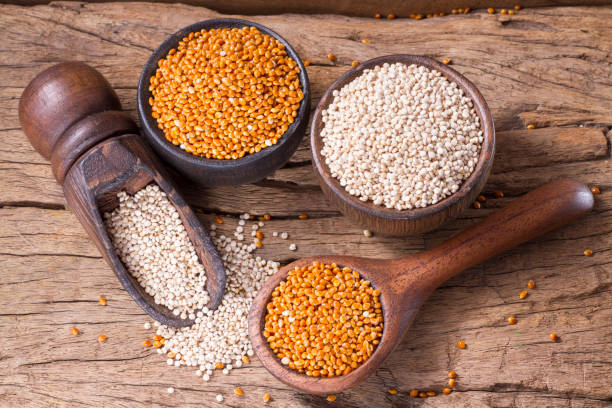 quinoa seeds and red millet - quinoa spoon wood photography imagens e fotografias de stock